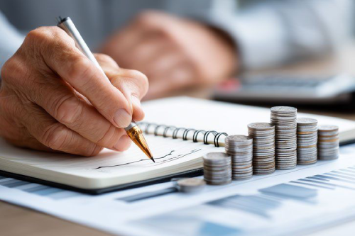 Pessoa fazendo planejamento financeiro com calculadora e notas